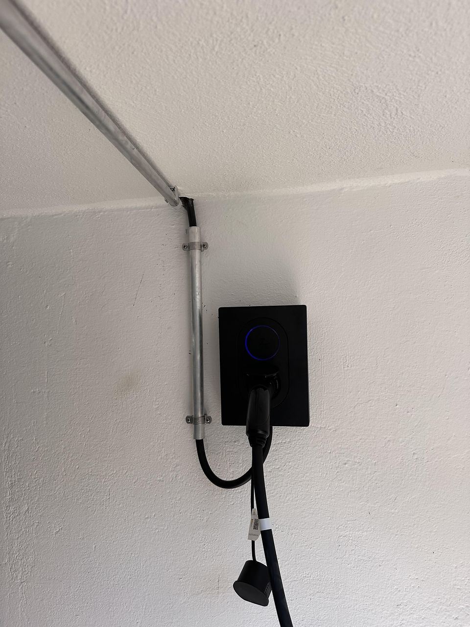 Fertig montierte Wallbox mit eingestecktem Ladekabel an einer Hauswand in Braunsbach